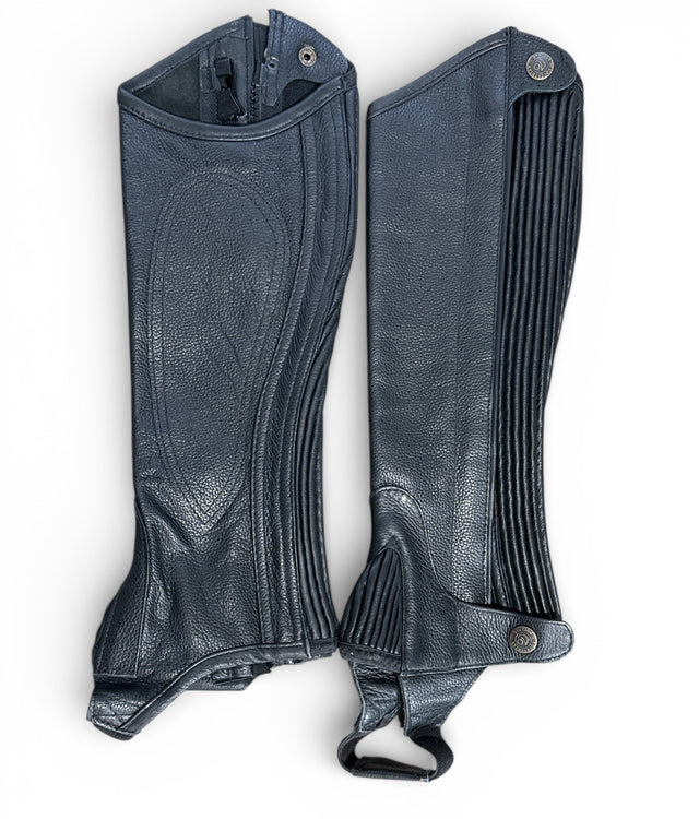 Pair of black leather gaiters on a white background