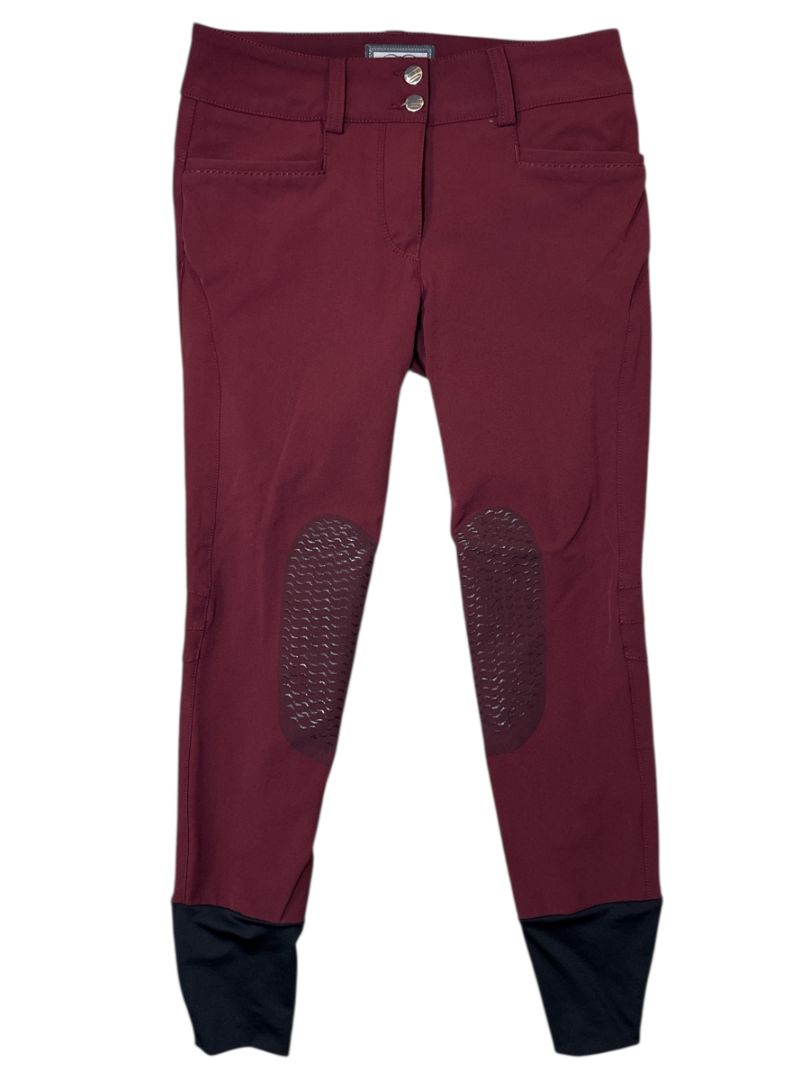 Maroon riding pants with knee patches on a white background