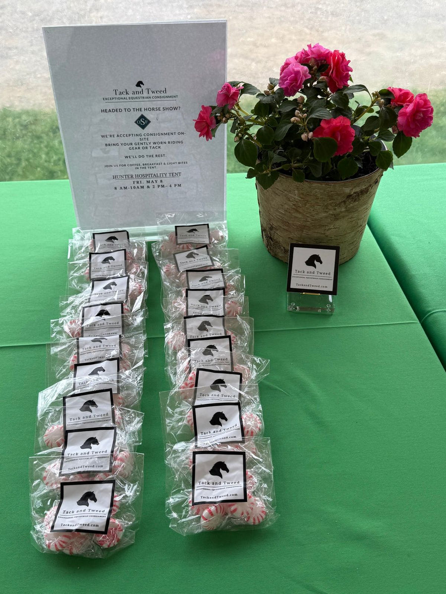 A dessert table with hydrangeas, Tack and Tweed cookies tied with black ribbon, horseshoe treats and a partner’s sign on a horse-print tablecloth.